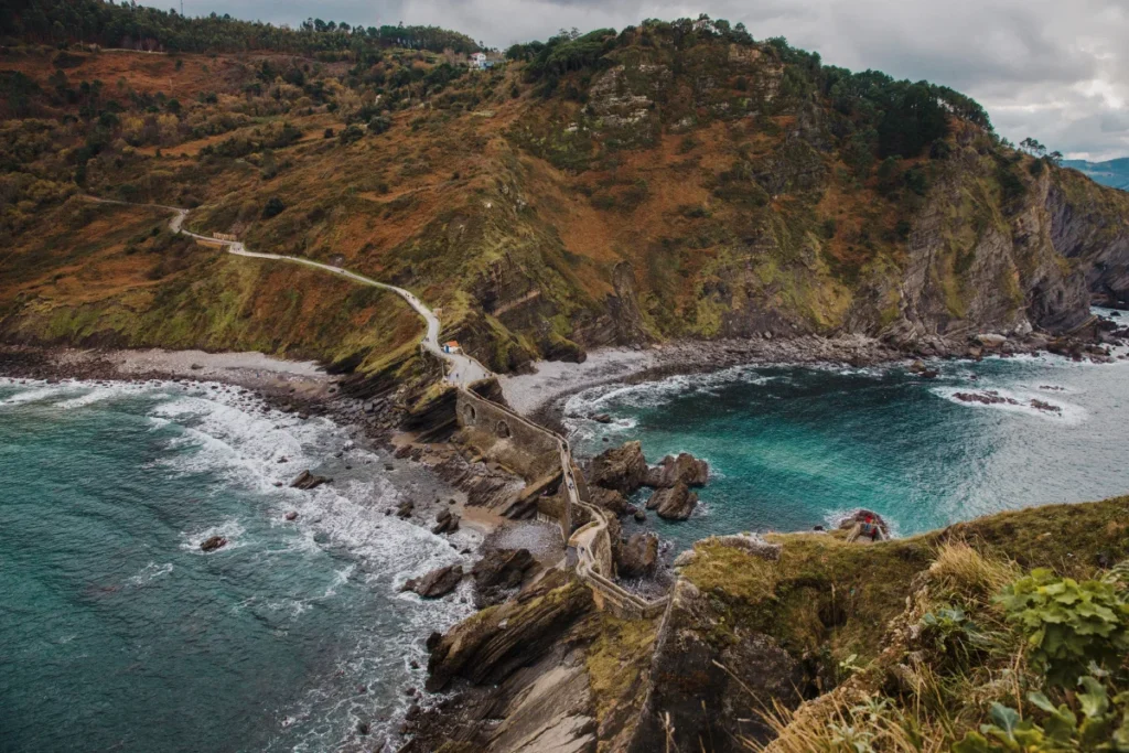 Каменный мост и лестница к Сан-Хуан-де-Гастелугаче (San Juan de Gaztelugatxe), Бискайя. Вид со стороны островка на побережье.